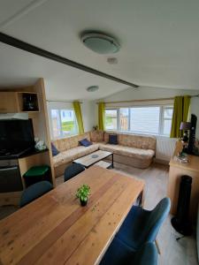 Biville-sur-MerLe Cocooning的客厅配有木桌和沙发