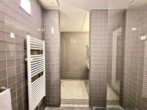 伊斯基亚Roccobarocco Boutique Hotel的带淋浴的浴室和灰色的瓷砖墙壁