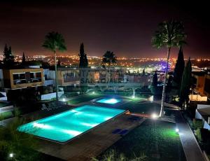 吉亚Apartamento Vitismar CA的享有城市美景的夜间游泳池
