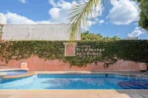 瓦哈卡市Suites Parador Santo Domingo de G.的一座游泳池,在建筑物的一侧有标志