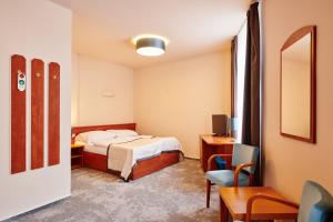 温佩尔克特瑞莎酒店的酒店客房,配有一张床、一张桌子和椅子
