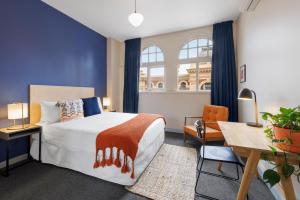 墨尔本Selina Central Melbourne的一间卧室配有一张床、一张书桌和一个窗户。