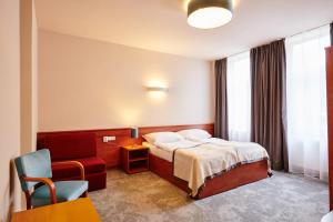 温佩尔克特瑞莎酒店的配有一张床和一把椅子的酒店客房