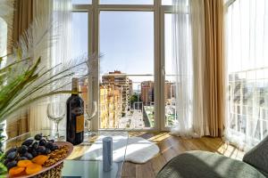 马拉加Perla de Malagueta的客房设有带一瓶葡萄酒的桌子和窗户。