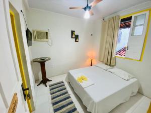 卡拉韦拉斯Pousada do beco的卧室配有白色的床和窗户。