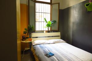 米兰考拉旅舍的一间卧室配有一张床和一个植物窗户