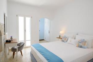 阿莫尔戈斯Tholariani Villas的白色卧室配有床和书桌