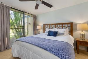 卡胡库Gorgeous One Bedroom golf course front的一间卧室配有一张带蓝白色床单的大床