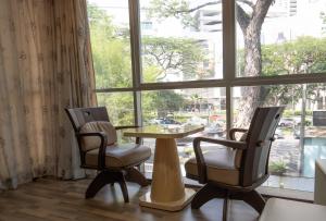 乔治市Cozy Gurney Georgetown Private Apartment Penang的窗前的两把椅子和一张桌子