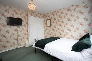奇德尔休姆Hurley House的卧室配有一张床,墙上配有电视。