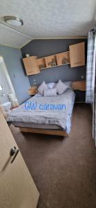 Kinmel BayWhitehouse Leisure Park North wales 6 birth caravan的卧室配有一张带立方大篷车的床