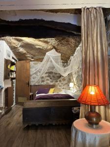 TolvaCASA NOTARI - Casa Rural Zona Congost de Montrebei的一间卧室配有一张石墙床