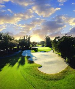 布雷登顿Americas Best Value Inn Bradenton-Sarasota的享有高尔夫球场和河流的空中景致