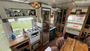 斯卡伯勒2 x Double Bed Glamping Wagon at Dalby Forest的厨房配有炉灶和餐桌。