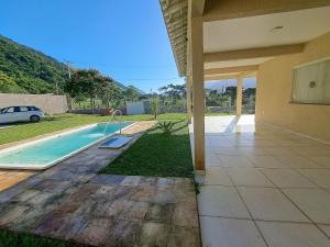 加克内Casa de campo Ar piscina Churrasqueira Saquarema的庭院中带游泳池的房子