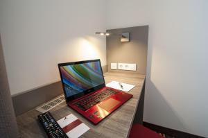 贝格基兴阿马罗酒店的坐在遥控器旁边的桌子上的笔记本电脑
