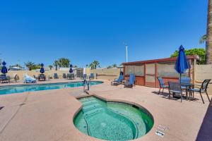 优马Pet-Friendly Yuma Vacation Rental with Pool Access!的游泳池配有椅子、桌子和遮阳伞