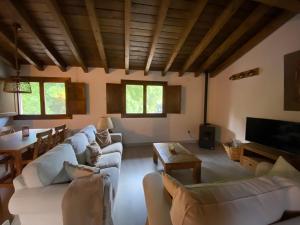 赫尔特Casa rural en jerte: La casa del molino的客厅配有白色的沙发和桌子
