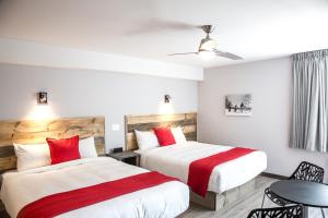 Val-MorinHôtel Far Hills的两张位于酒店客房的床铺,配有红色枕头