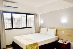 累西腓Aram Beach Boa Viagem的一间卧室设有一张大床和大窗户