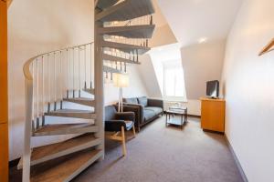 霍鲁梅尔希尔鲁切特芬恩酒店的客厅设有螺旋楼梯和沙发