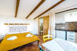 波萨达Panoramic Loft con uso cucina ,Casa Raimonda, Ammentos Posada的一间带黄色床的卧室和一间厨房