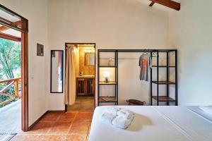 圣塔特蕾莎海滩Casa Calocita的一间带白色床的卧室和一间浴室