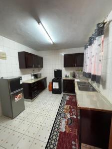 基苏木Lefad Apartment-3Bedrooms own compound的厨房配有黑色家电,铺有瓷砖地板。