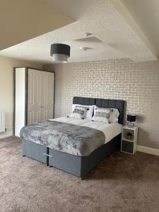 史云顿Swindon City Center 2bed apartment with Parking and WiFi的一间卧室设有一张床和砖墙