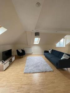 史云顿Swindon City Center 2bed apartment with Parking and WiFi的客厅配有蓝色的沙发和电视