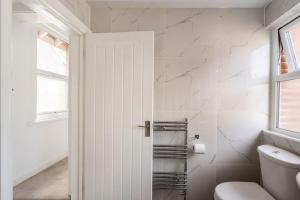 沃金Maybury Maison的白色的浴室设有卫生间和窗户。