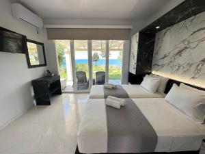 圣斯特凡诺斯Nikos Apartments Corfu的一间带两张床的卧室,享有海景