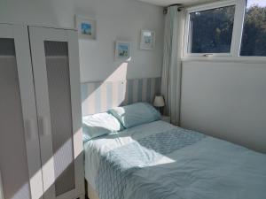 赫彻姆Heacham Hideaway的一间小卧室,配有床和窗户