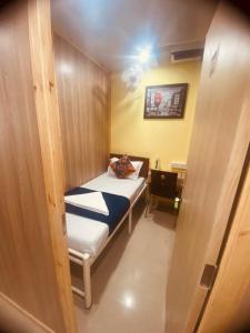 孟买Royal Cabin Stay的小房间设有一张床和一张书桌