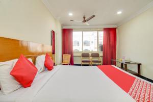 蒂鲁帕蒂OYO Srinivasa Residency的一间卧室配有一张带红色枕头的大床