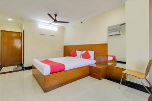 蒂鲁帕蒂OYO Srinivasa Residency的一间卧室配有一张床和一把椅子