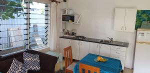 拉罗汤加苍鹭礁度假公寓的带桌子的厨房和带水槽的厨房