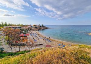 帕拉利米尼Villa Angel - Exotic Villa 200m From Beach的海滩上设有椅子和遮阳伞,还有大海