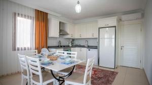 卡斯VİLLA TANYERİ的厨房配有桌椅和白色冰箱。