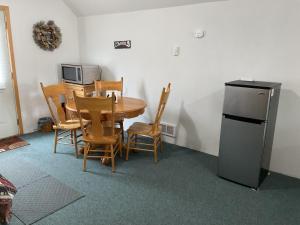 3G Farms Studio的厨房配有桌椅和冰箱。
