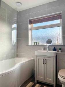 赫彻姆Modern Coastal 2 Bedroom Home to Relax and Unwind的带浴缸、盥洗盆和卫生间的浴室