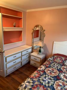 大洋城ELIS APARTMENT的一间卧室配有一张床、梳妆台和镜子