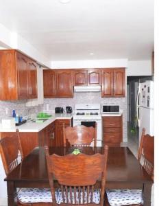 多伦多Raised bungalo的厨房配有木制橱柜和桌椅