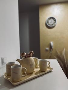 克拉列沃Apartman Puket的盘子上装有三杯茶壶
