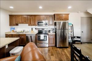 VineyardFamily-friendly Suite with HotTub MemoryBeds SmartTV的厨房配有木制橱柜和不锈钢冰箱。