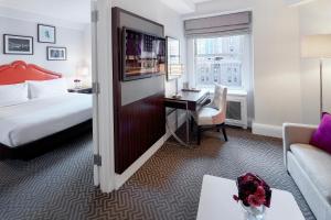 纽约The Lexington Hotel, Autograph Collection的配有一张床和一张书桌的酒店客房