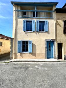 巴涅尔德比戈尔Le gîte du bonheur的一边有蓝色百叶窗的房子