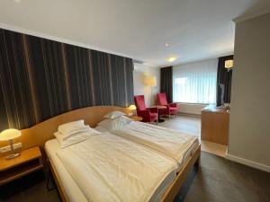 黑耶拉特阿尔贝茨兰德酒店的酒店客房带一张大床和两张椅子