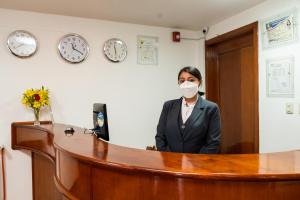 库斯科Kenamari Hotel Cusco的办公室里戴面具的女人