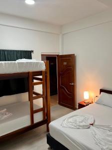 帕洛米诺Hostal Grand Park Palomino的一间卧室配有两张双层床和一个衣柜